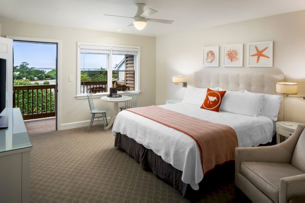 Sanderling Resort's tidy hotel room with a bed, art on the wall, and a balcony view.