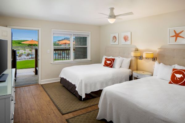 Sanderling Resort's tidy bedroom with twin beds, nautical decor, and an oceanside view.