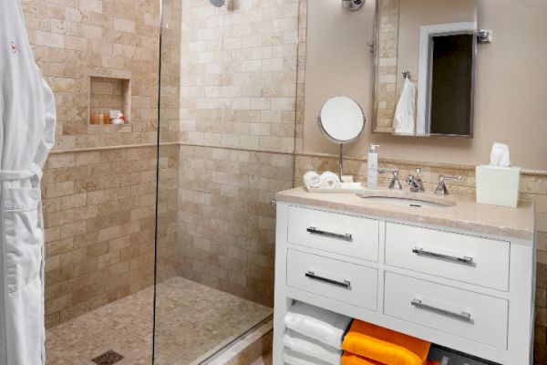 Sanderling Resort's modern guest bathroom with a glass shower, vanity, and towels.