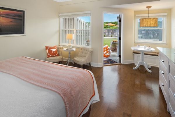 Sanderling Resort's neatly furnished guest bedroom with a bed, chairs, desk, tv and access direct oceanside amenity access.